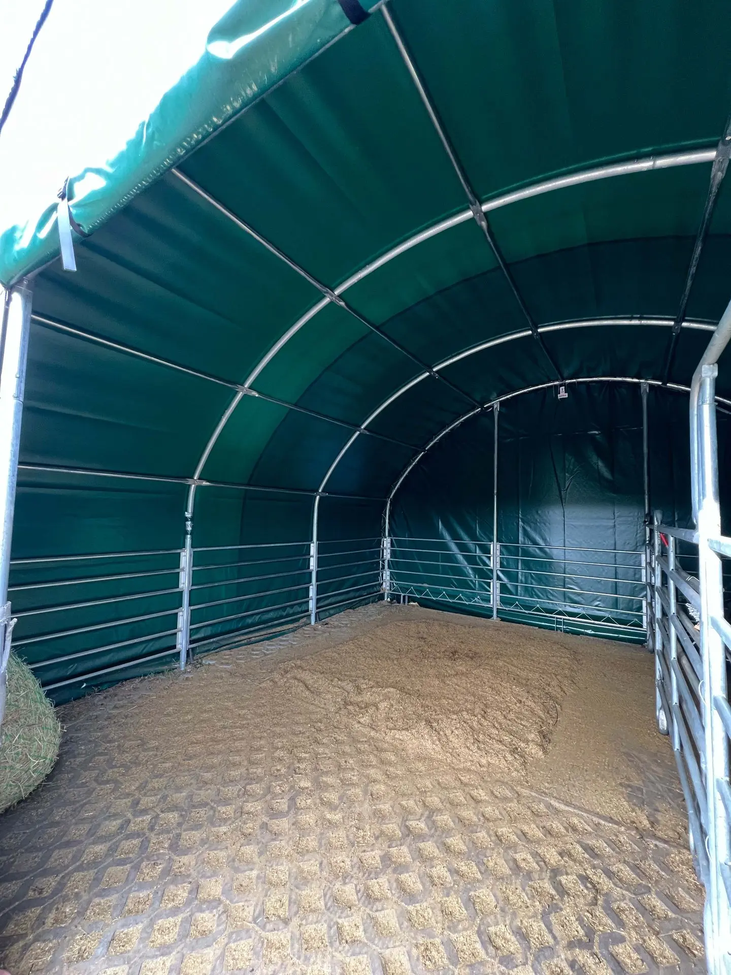 Strohgranulat in einem Offenstallzelt als Pferdeeinstreu
